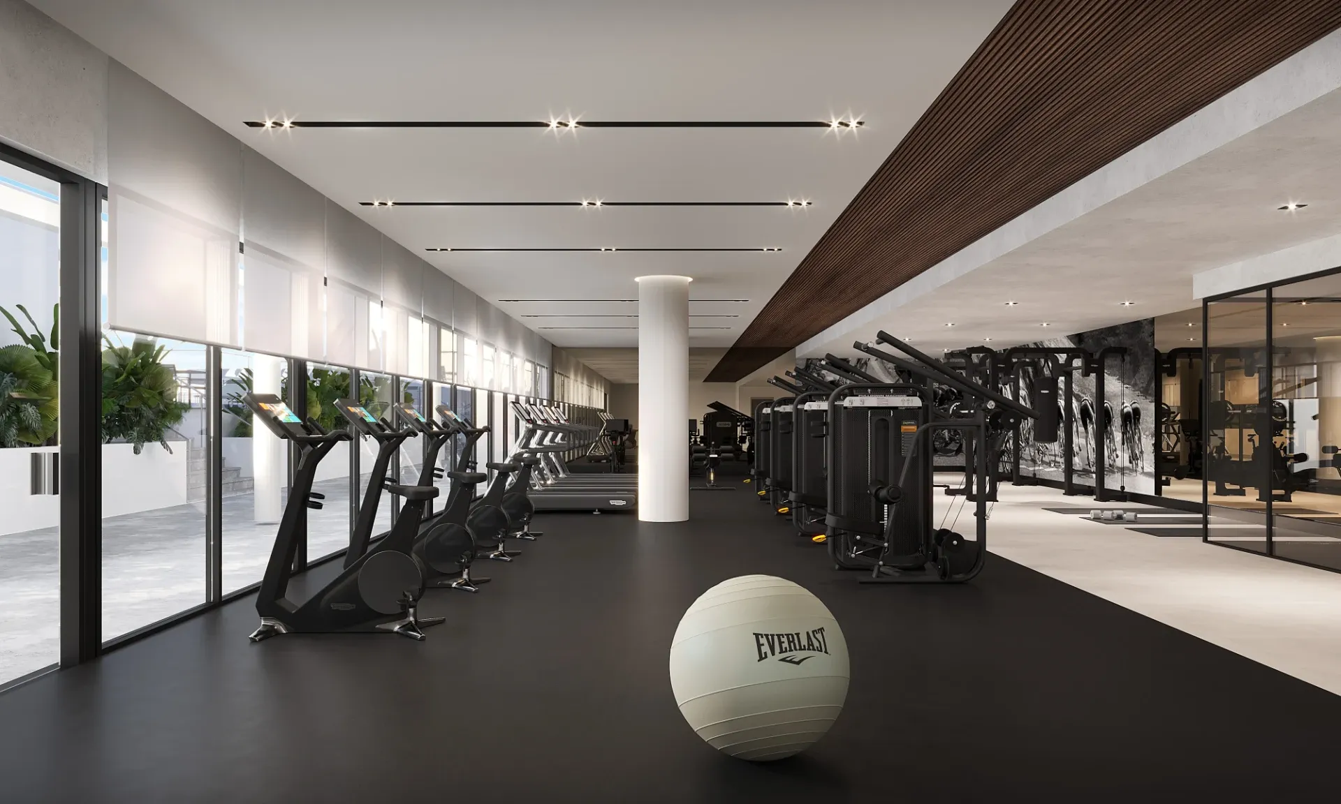 A sleek fitness center with a wall of windows and top-of-the-line cardio and strength equipment
